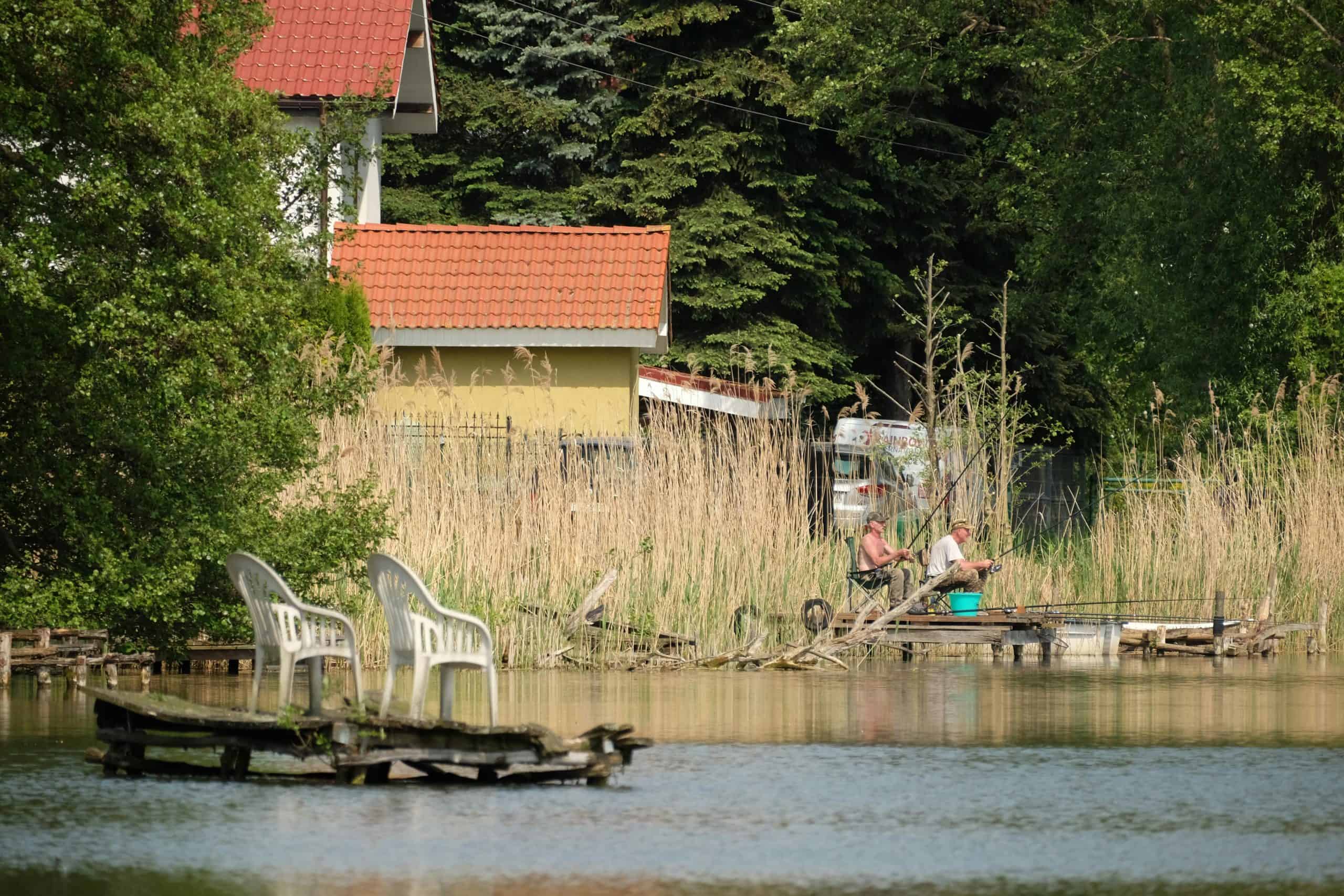pexels-szafran-27268745 2 people sitting on a dock fishing