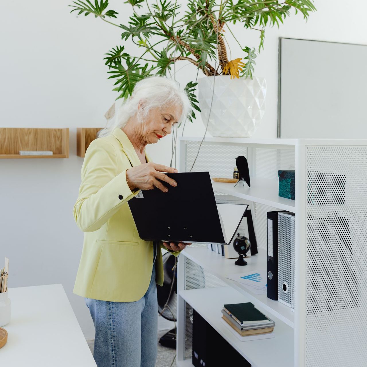 pexels-karola-g-8530116 Elderly businesswoman sorting folders in a modern office space